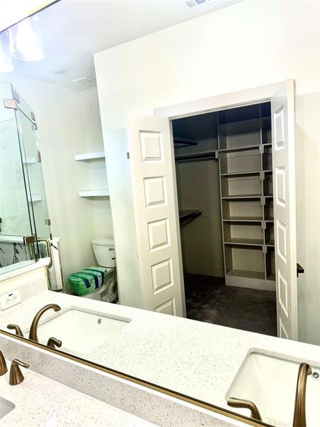 Bathroom featuring toilet, a shower with shower door, and vanity