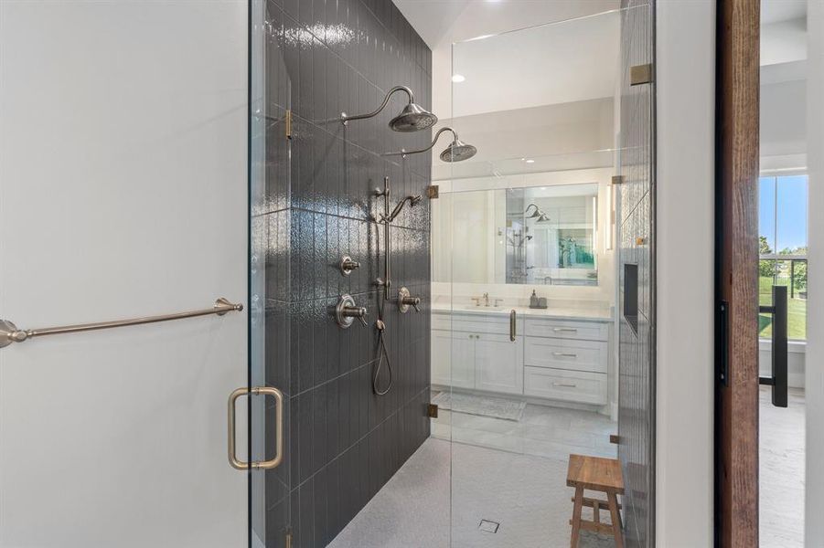 Bathroom featuring tile floors, walk in shower, and vanity