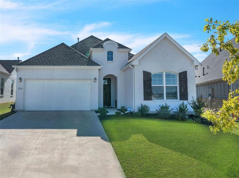 View of front of home with a garage and a front yard