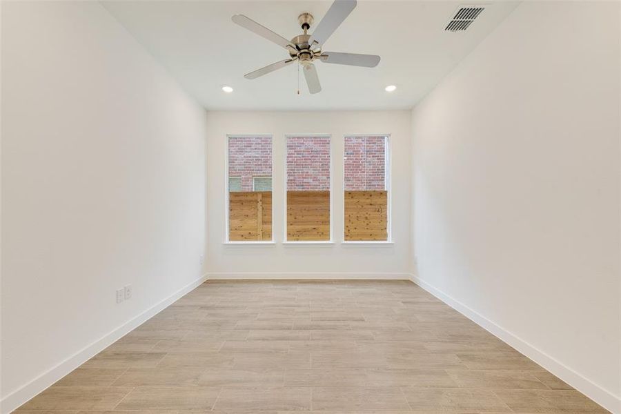 Empty room with ceiling fan and light wood-type flooring