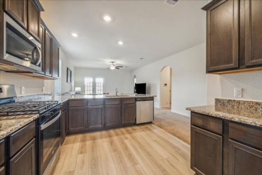 Kitchen: Stainless Appliances, Dark Cabinets, Granite Counters, Vinyl Plank Floors