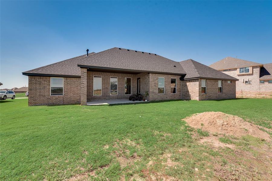 Back of property featuring a lawn and a patio area