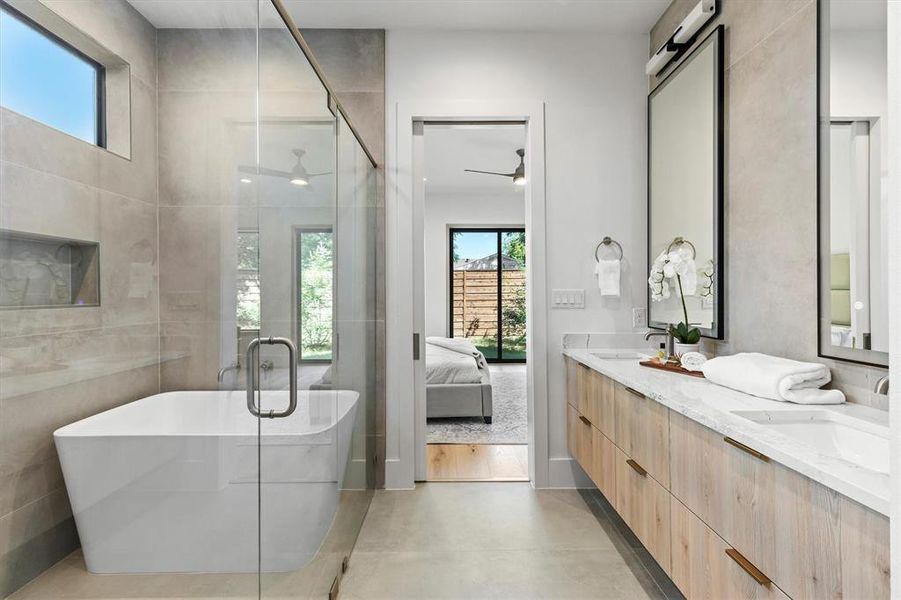 Bathroom with ceiling fan, vanity, plus walk in shower, and tile walls