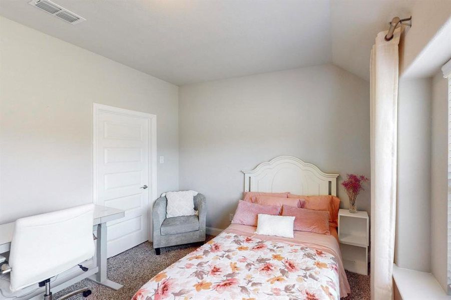 Carpeted bedroom featuring vaulted ceiling