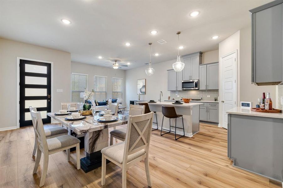 Dining space with light hardwood / wood-style flooring, ceiling fan, and sink