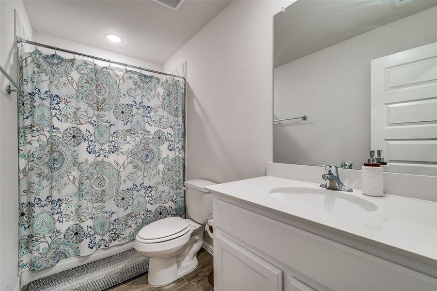 Bathroom with hardwood / wood-style floors, vanity, toilet, and walk in shower