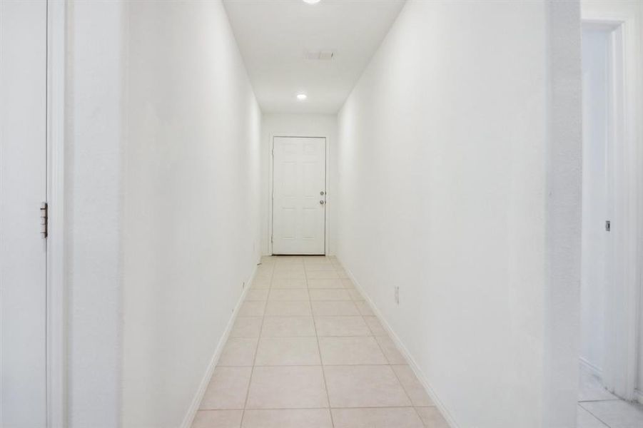 Hall featuring light tile patterned floors