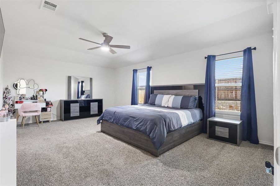 Bedroom featuring multiple windows, carpet, and ceiling fan