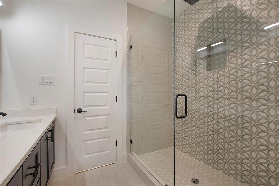 Bathroom featuring a shower with door and vanity