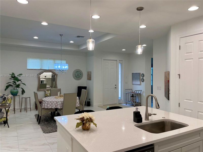 The kitchen island, dining, and main entry as viewed from the kitchen