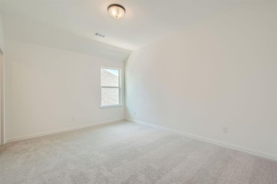 Carpeted spare room with lofted ceiling