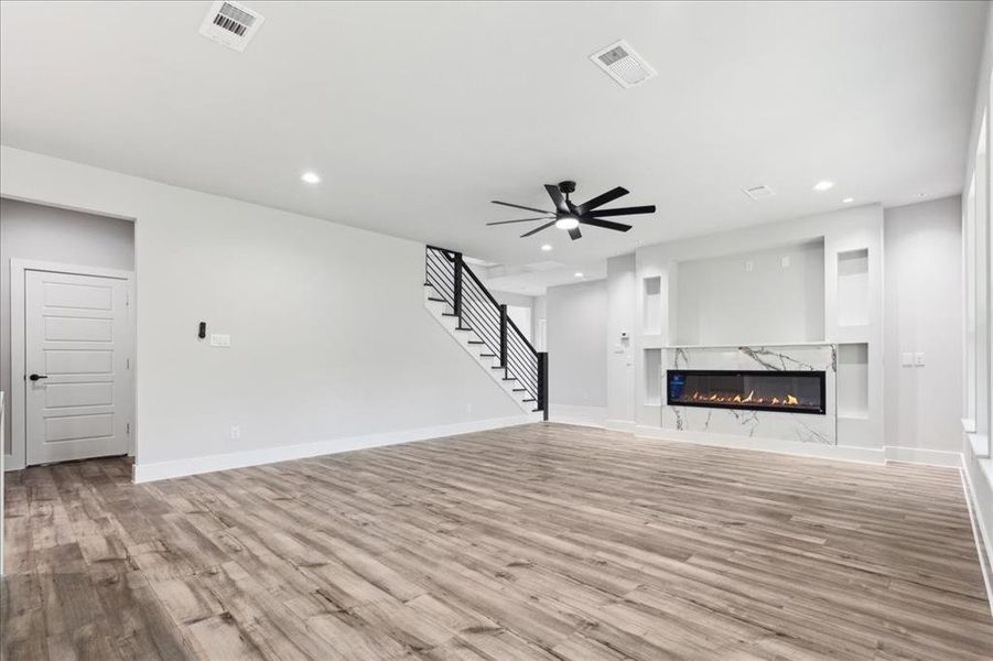 Unfurnished living room with a high end fireplace, and ceiling fan