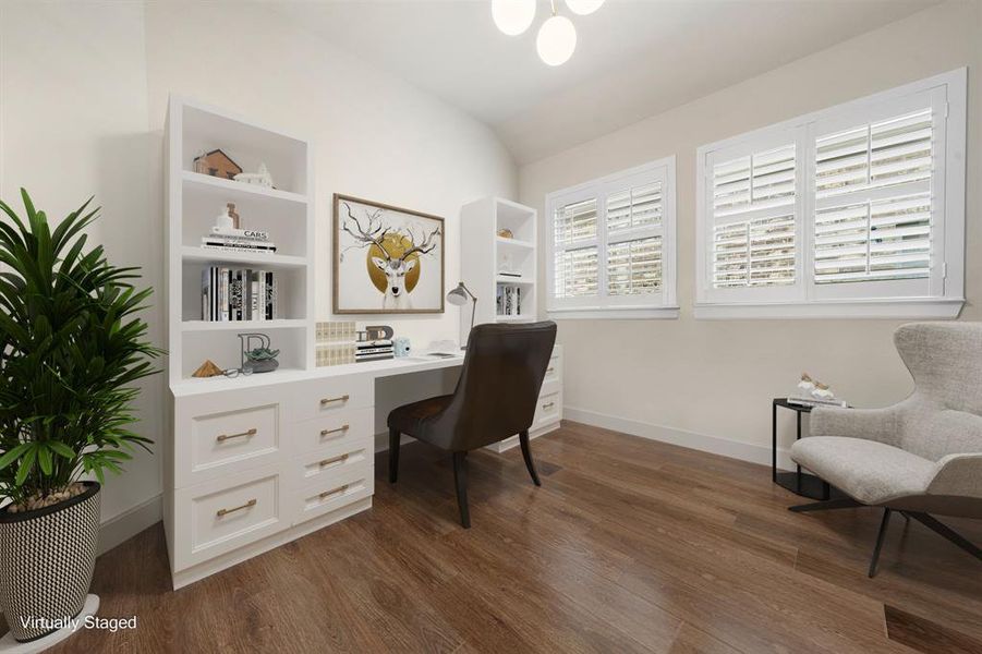 Nestled away privately is the handsome and grand home office. Featuring high ceilings, custom chandelier, neutral paint, rich wood laminate flooring, and large windows with plantation shutters.