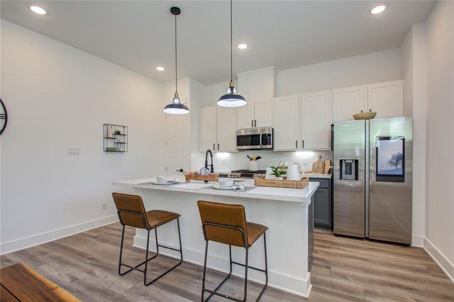 This attractive Kitchen is full of beautiful details. Quartz Countertops, Stainless Apron Sink, Stainless Steel Appliances, Recessed Lighting, Undercabinet lighting, Pantry, Elegant Cabinetry with Soft Close Drawers and Doors. Model home photos - FINISHES AND LAYOUT MAY VARY! Ceiling fans are NOT INCLUDED!