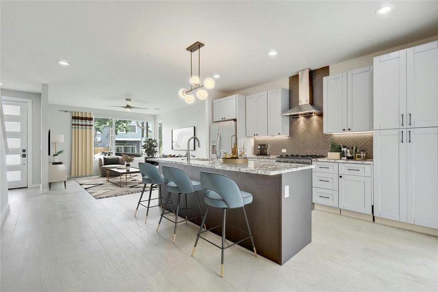 This chef's kitchen features a center island and breakfast bar, providing ample space for meal preparation, casual dining, and socializing with guests. *Virtually Staged*