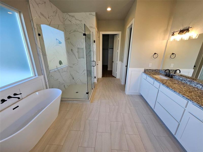 Stunning primary bathroom with double sinks, soaker tub, and separate shower
