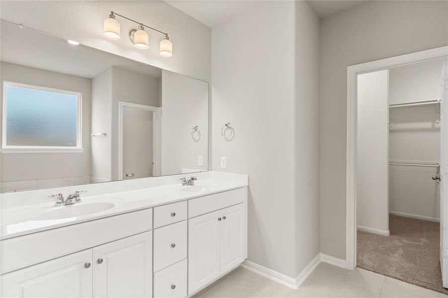 The en-suite bathroom offers a spa-like atmosphere with its elegant design, high end finishes, and tasteful lighting, creating a retreat within your own home.