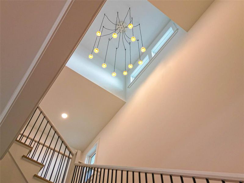 An elegant lighting array gracefully illuminates the staircase, enhancing the modern interior with a warm, inviting glow.