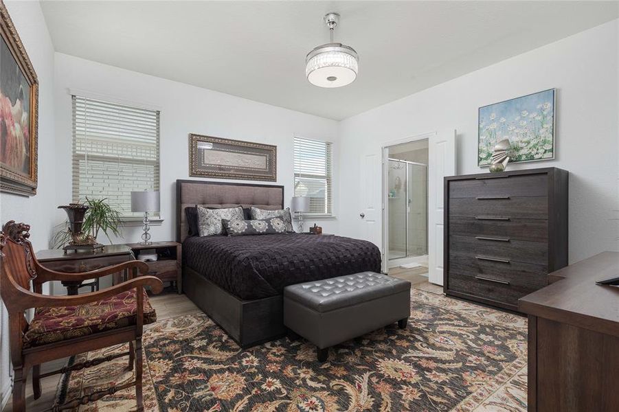 Bedroom with light wood-type flooring and ensuite bathroom