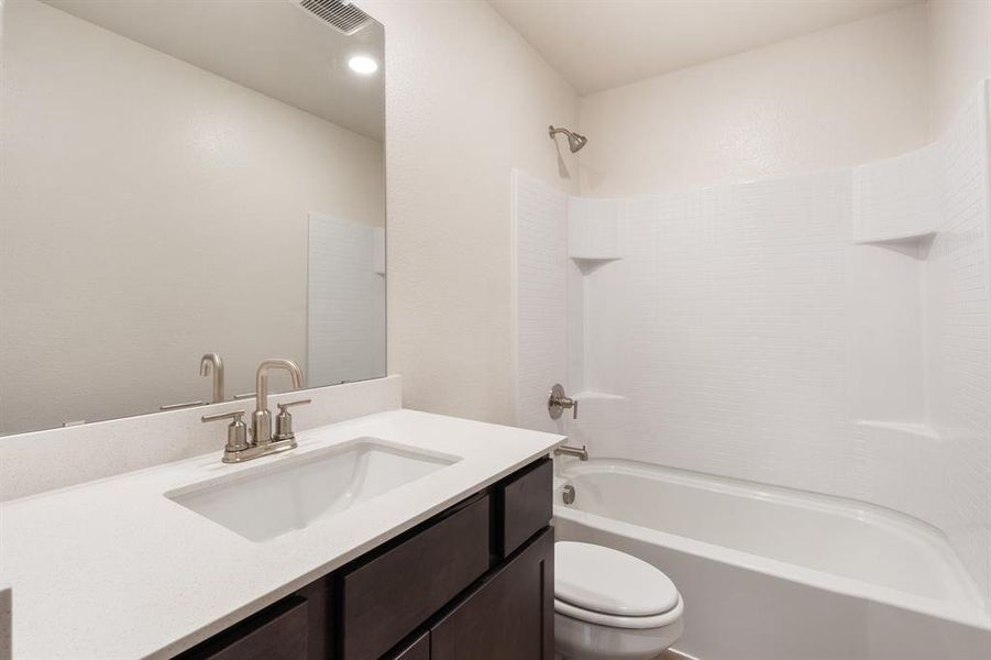 Full bathroom featuring vanity, toilet, and shower / tub combination