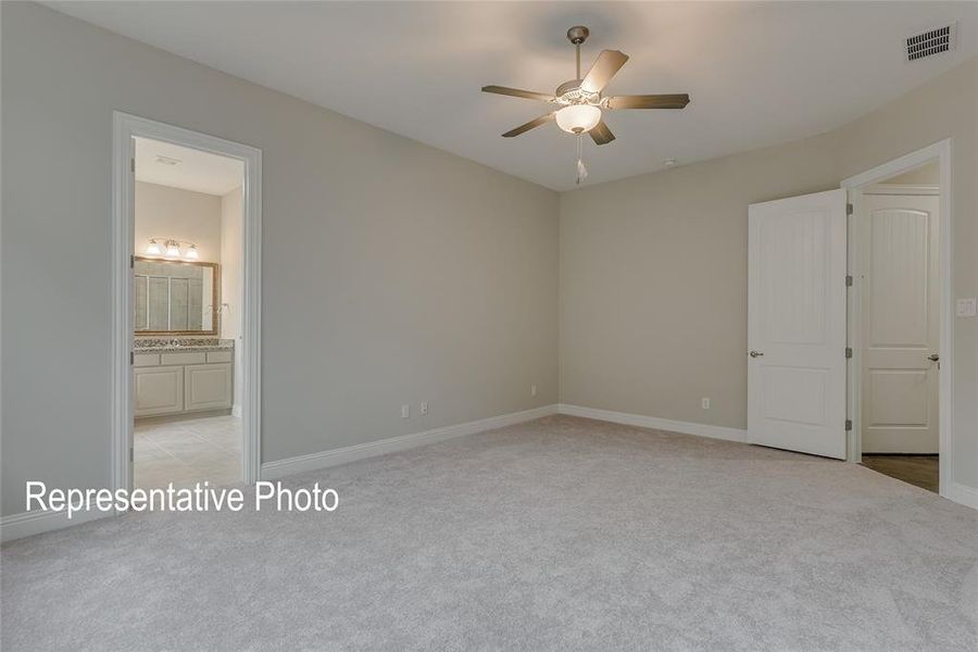 Unfurnished bedroom with light carpet, ensuite bath, and ceiling fan