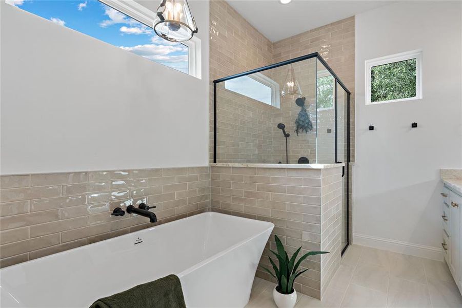 Bathroom with vanity, tile patterned floors, independent shower and bath, and a wealth of natural light