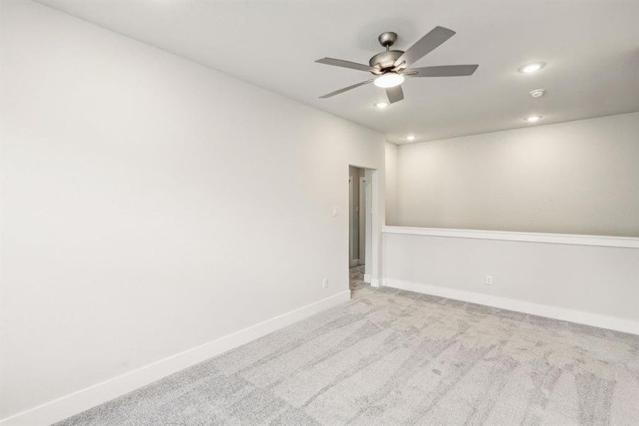 Carpeted empty room with ceiling fan