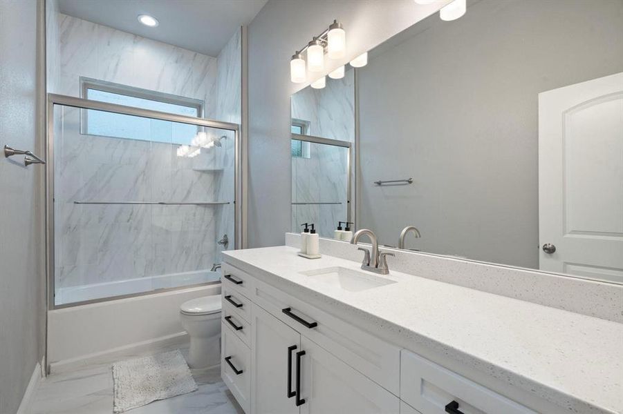 Full bathroom with shower / bath combination with glass door, toilet, and vanity