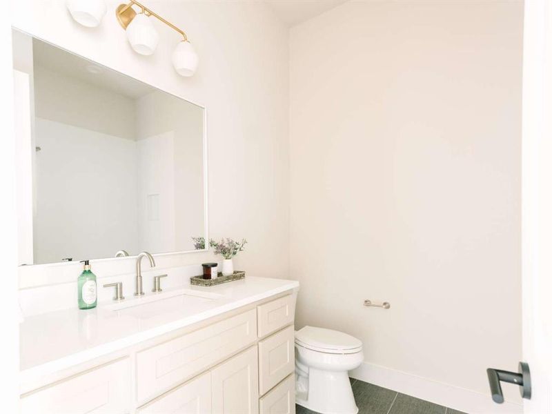 Bathroom with vanity, toilet, and tile patterned flooring