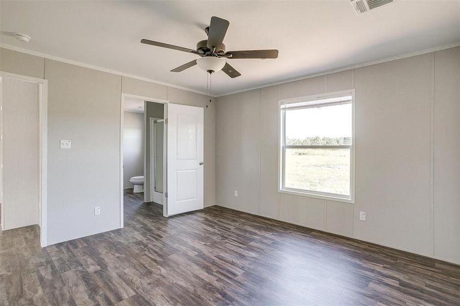 Unfurnished room with ornamental molding, ceiling fan, and dark hardwood / wood-style floors