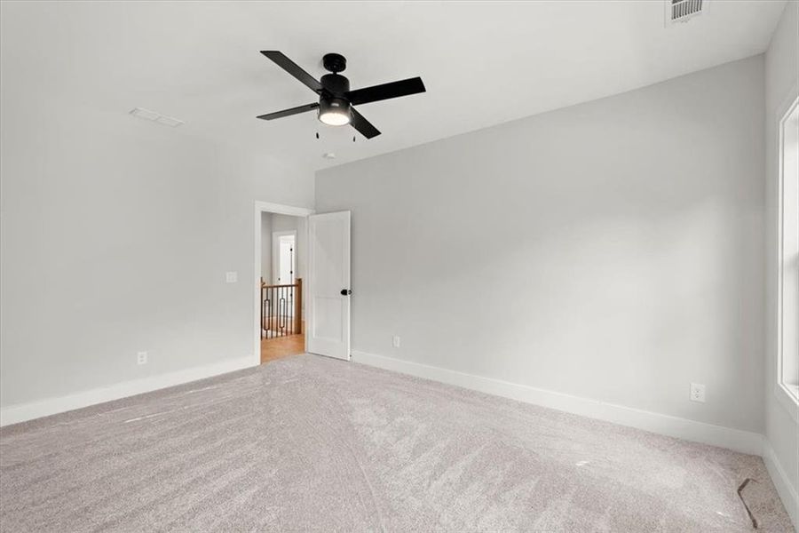 Carpeted empty room with ceiling fan