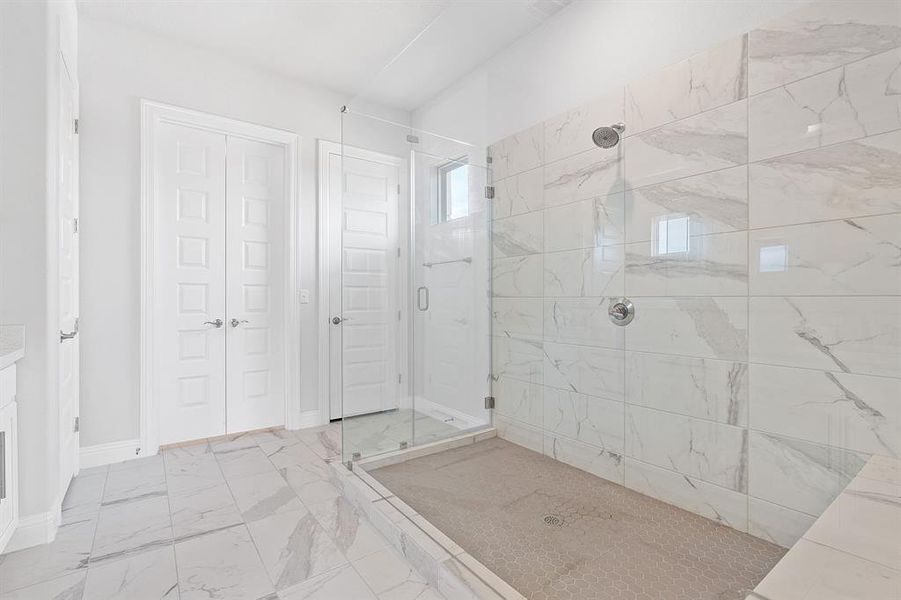 Extra large frameless glass shower in primary bathroom