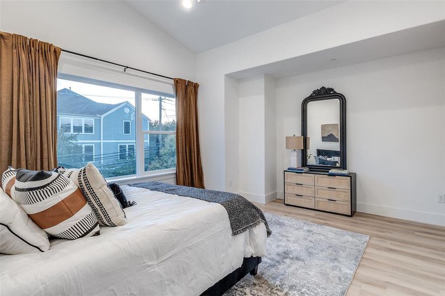 Bedroom featuring light wood-type flooring and vaulted ceiling