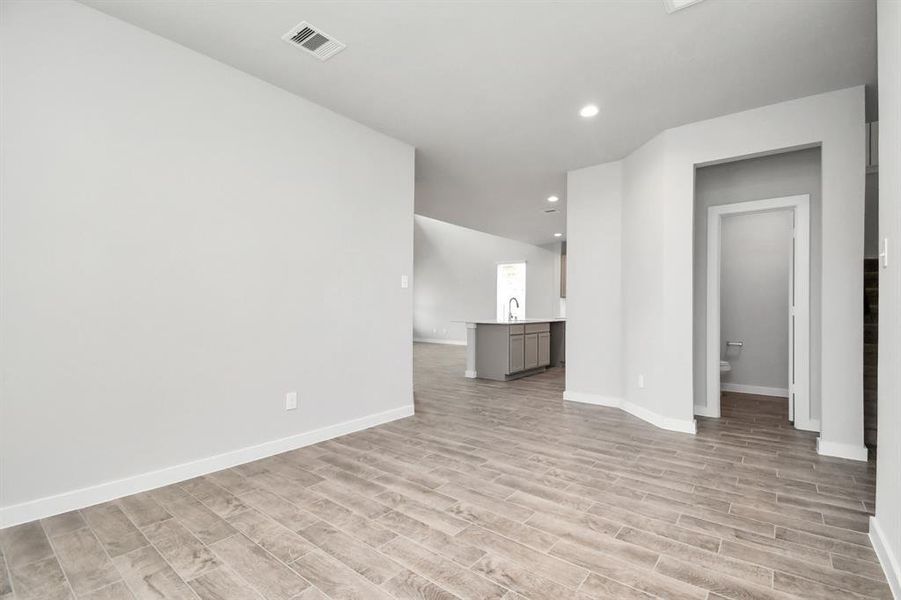 Create lasting memories with your family and friends at the dining table in this expansive dining room. It showcases sophisticated flooring, custom paint, and seamlessly connects to the family room and kitchen, providing an open and inviting atmosphere.