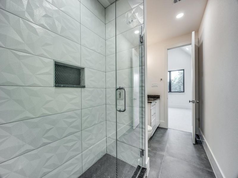 Bathroom featuring a shower with shower door, toilet, concrete floors, and vanity