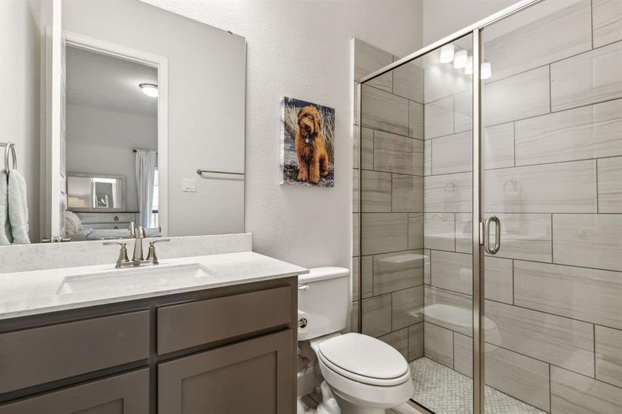 Bathroom with vanity, toilet, and an enclosed shower