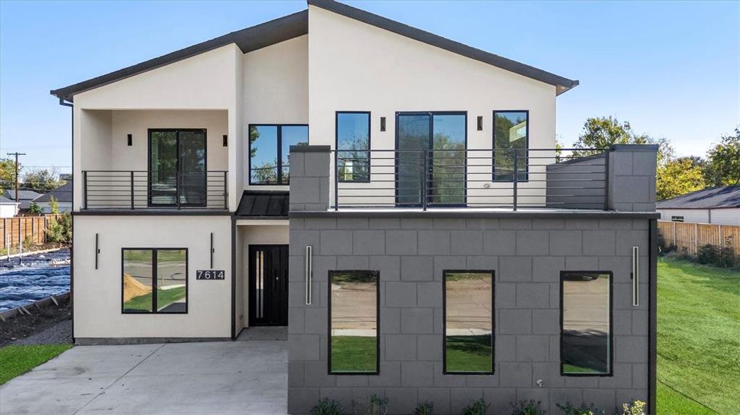 Rear view of house with a yard, a patio area, and a balcony