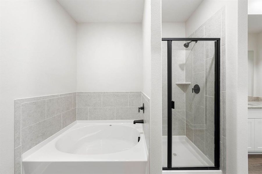 Bathroom featuring vanity and separate shower and garden tub