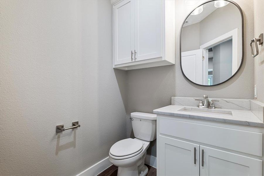 Bathroom with vanity, hardwood / wood-style floors, and toilet