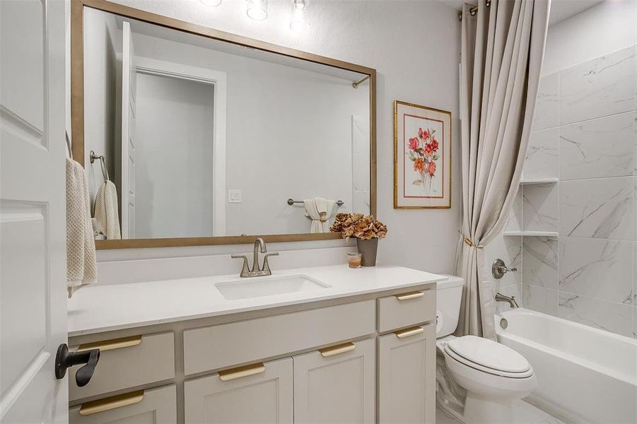 Full bathroom featuring toilet, vanity, and shower / tub combo