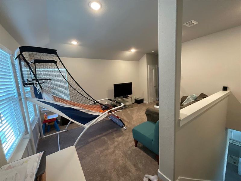 Exercise room with a healthy amount of sunlight and dark carpet