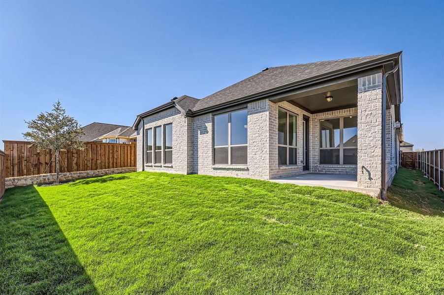 Rear view of property featuring a patio area and a lawn