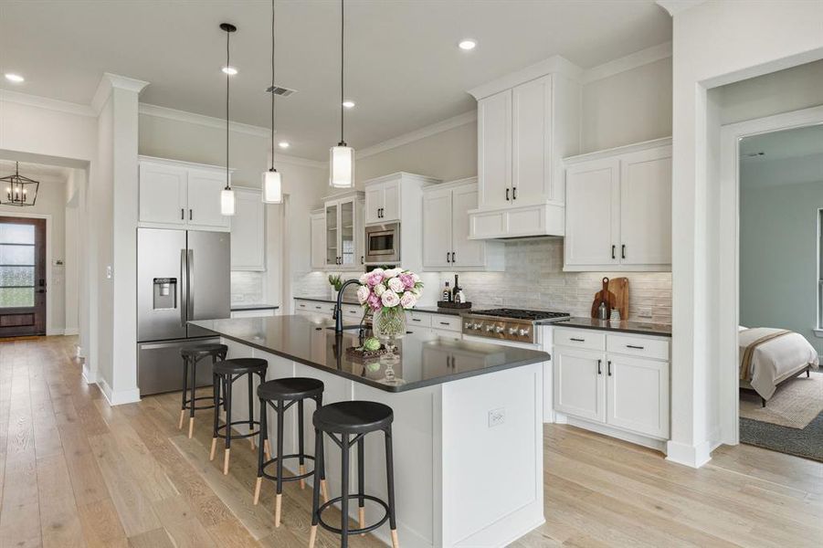 Kitchen featuring stainless steel appliances, light hardwood / wood-style floors, and white cabinetry *VIRTUAL STAGING