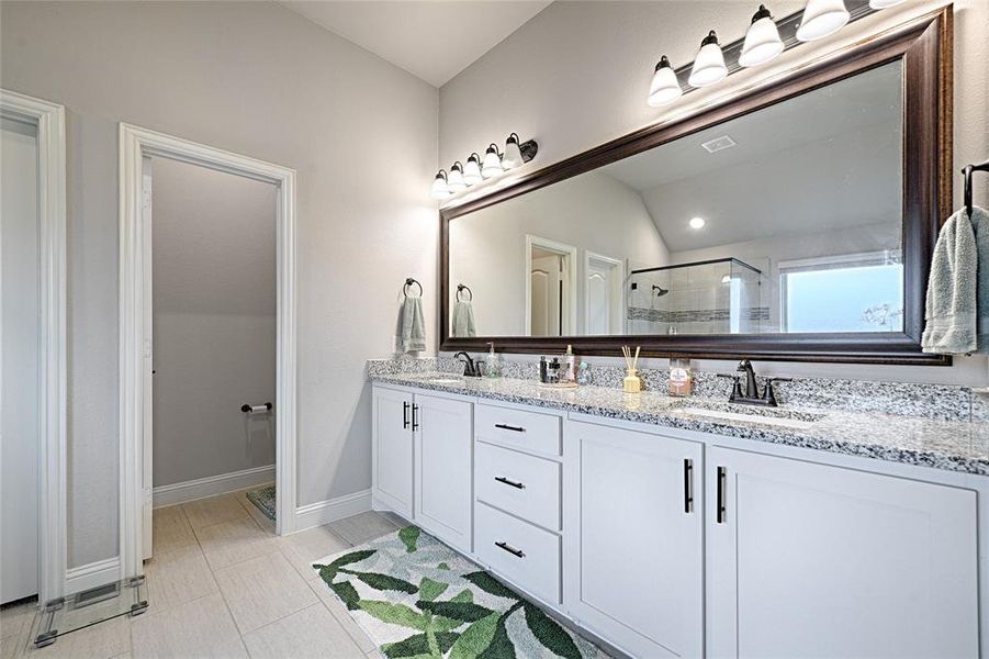 Bathroom with vanity, tile patterned flooring, lofted ceiling, and an enclosed shower