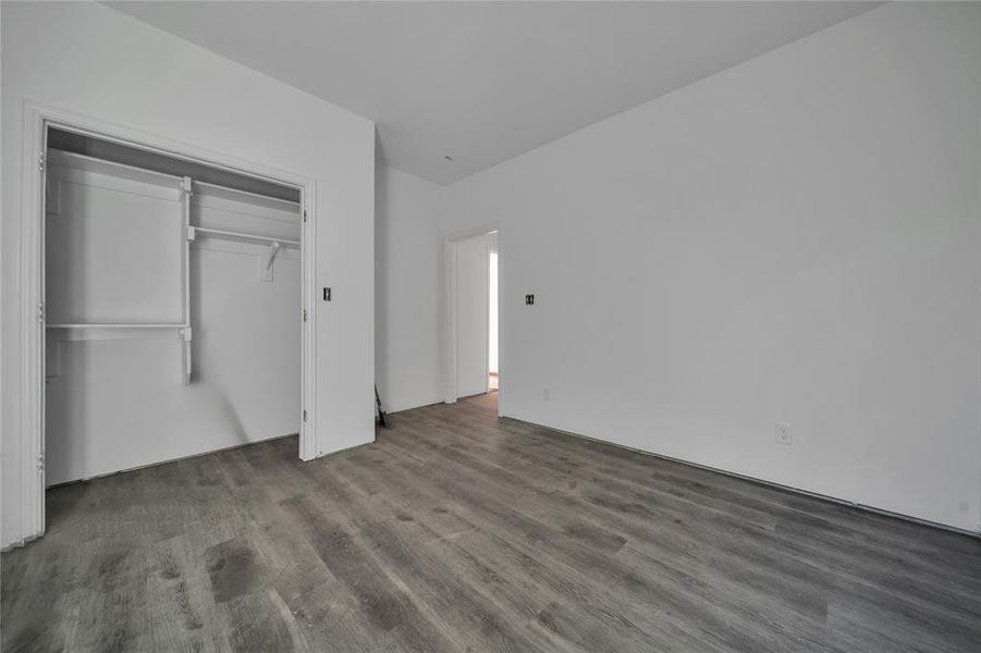 Unfurnished bedroom with dark hardwood / wood-style floors and a closet