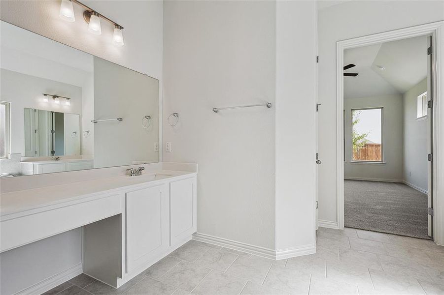 Bathroom featuring vanity, ceiling fan, lofted ceiling, and tile patterned floors