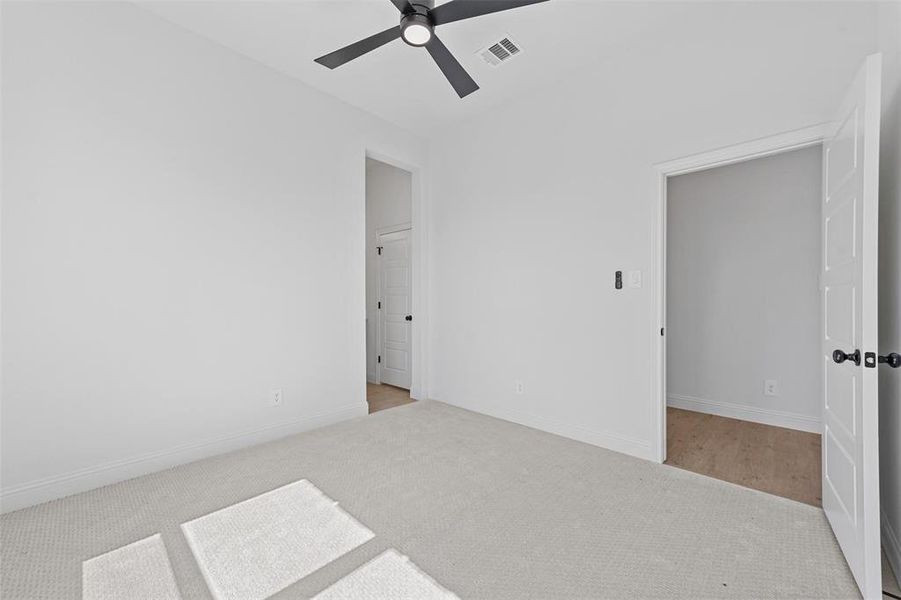 Spare room with ceiling fan and light carpet