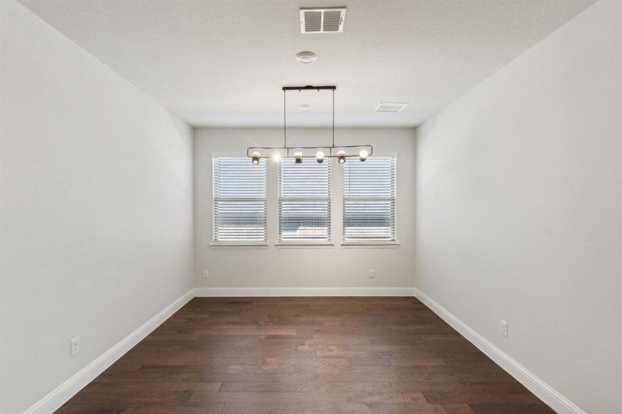 Unfurnished room featuring hardwood / wood-style flooring and a chandelier