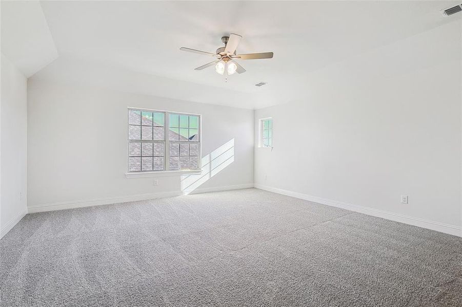 Carpeted spare room with lofted ceiling and ceiling fan