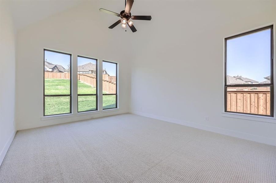 Unfurnished room with carpet flooring, high vaulted ceiling, and ceiling fan